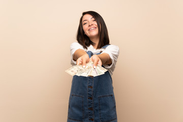 Young Mexican woman over isolated background taking a lot of money