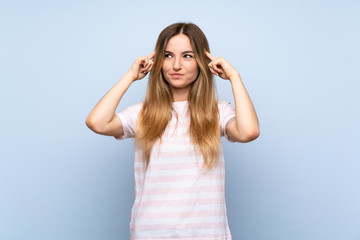 Young woman over isolated blue background having doubts and thinking