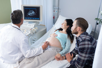 Doctor doing ultrasound scan for pregnant woman in hospital