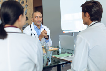 Obraz premium Medical team sitting and discussing with each other at the table