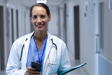 Female doctor looking at camera in the corridor at hospital