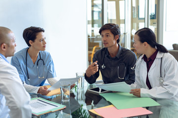 Medical team discussing with each other at the table in hospital - Powered by Adobe