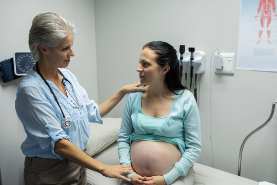 Female doctor talking with pregnant woman in examination room
