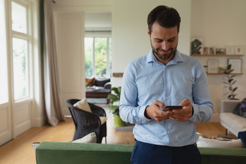 Man using mobile phone in a comfortable home