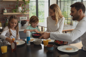 Caucasian family having food at dining table