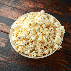 bowl of salty popcorn on wooden table