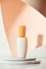 Skincare product serum bottle mockup sample styling on beige table with pink paper. Product studio styling shot