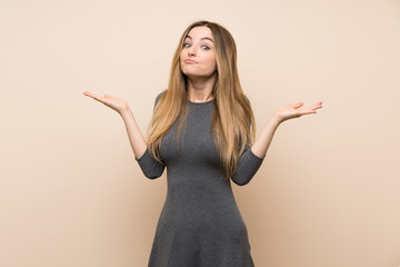 Young woman over isolated background making doubts gesture
