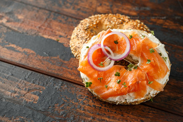 Bagels breakfast sandwich with Cream cheese and salmon on wooden table