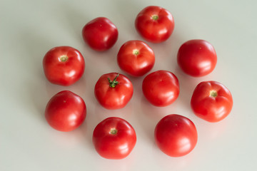 Fresh tomatoes on a white glass table. Harvesting tomatoes. Top view.