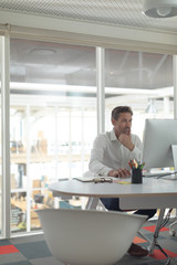 Business male executive working on computer at desk in a modern office