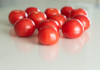 Fresh tomatoes on a white glass table. Harvesting tomatoes. Top view.