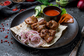 skewers of mutton flesh on black plate
