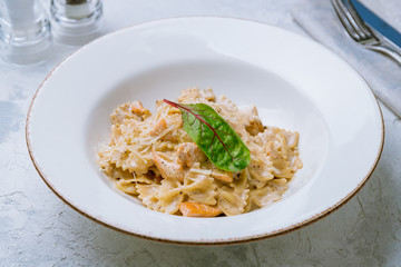 Farfalle with salmon on white plate
