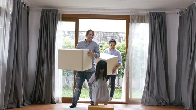 Concept of moving house. The family is carrying the box into the house.
