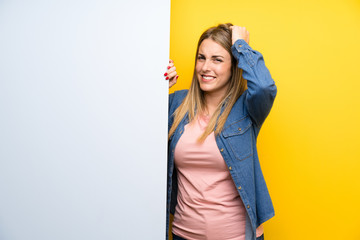 Young woman holding an empty placard unhappy and frustrated with something. Negative facial...