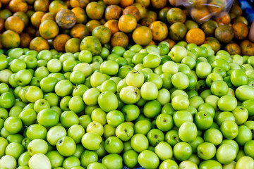 Stack of Raw Green fresh Monkey Apple or Indian Plum or Jujube  and Orange in Market.