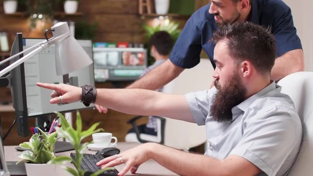 In creative media house two architects are talking about new project. They have a 3D software running a simulation