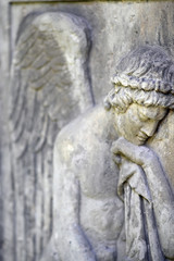 Partial view of a grieving angel. A sandstone relief of a mourning angel.
