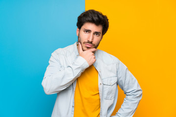 Handsome over isolated colorful background thinking