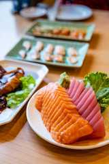 Salmon and Tuna Sashimi and Squid with Sauce Japanese Food on the Wood Table.
