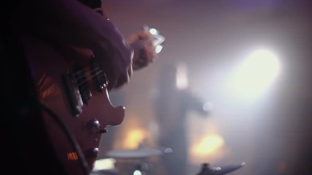Guitarist plays on the background of the singer at a live concert