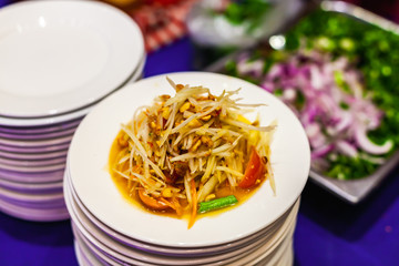 Papaya Salad or Somtam a Famous Thai Food on White Plate in Restaurant.