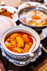 Massaman Chicken Curry in Porcelain a Famous Thai Food on Table.