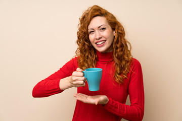 Redhead woman with turtleneck sweater holding hot cup of coffee