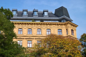 Modern roof of the vintage building through trees at autumn in Vienna Austria