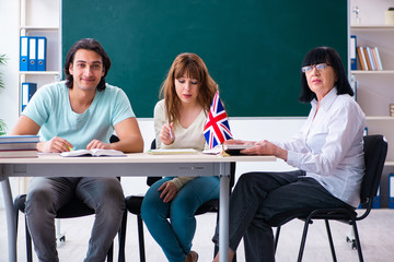 Old female english teacher and students in the classroom 