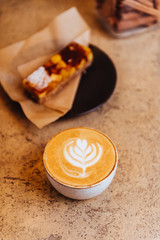 Coffee, cappuccino and cake on light texture background
