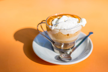 Italian espresso coffe with cream on a table in a sunny day