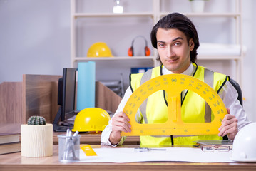 Young male architect working in the office 