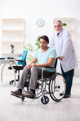 Male patient in wheel-chair visiting old doctor 