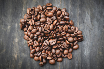 Coffee beans roasted on wood background