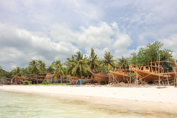 Obraz premium habor contructing wooden boads between palm trees at the beach