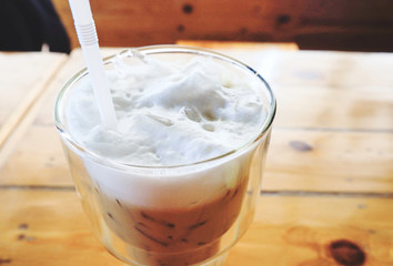 Iced coffee with milk in glass on the table