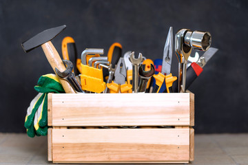 construction tools in wooden box in black background
