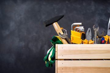 construction tools in wooden box in black background