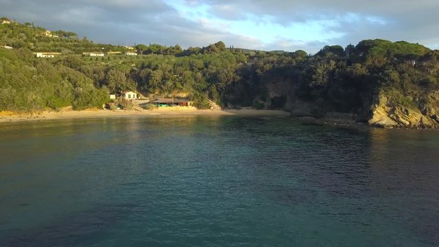 Aerial Drone Shot Flying Away from Spiaggia Zuccale Beach, Elba, Italy on a Calm Sunset Evening