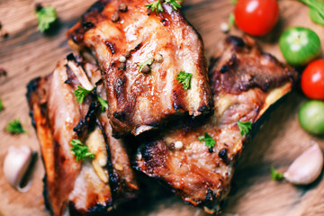 bbq pork ribs grilled with tomatoes herbs and spices on wooden cutting board - Roasted barbecue pork spare rib sliced