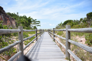 Fototapeta na wymiar Wooden walkway leading to the beautiful beach in Brazil