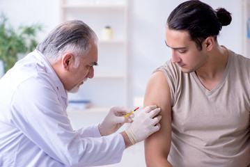 Male patient visitng doctor for shot inoculation 