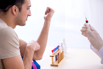 Young handsome man during blood test sampling procedure 