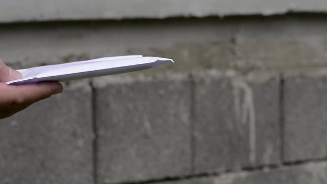 Young boy gives a white envelope with money  to another person, conceptual footage of bribe.