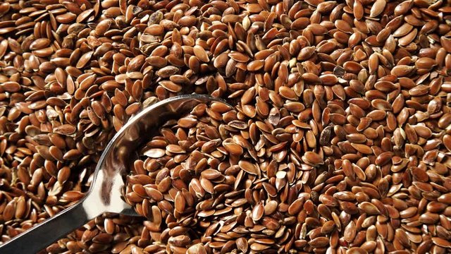Brown raw flax seeds linseed as natural food background or grain texture. Flaxseeds full of omega 3 fatty acids. Top down view. Healthy diet organic nutrition