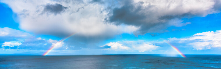 Fototapeta na wymiar Rainbow against blue sky, ocean and clouds, Northern Ireland
