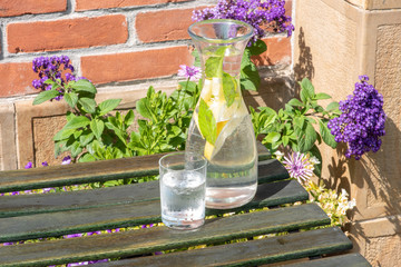 Glass and carafe of fresh cold water on garden table