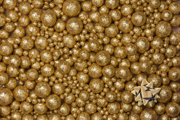 Christmas background with big and small golden glitter balls and golden ribbon star